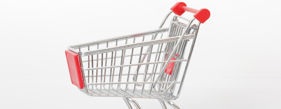 A small metal shopping cart with red plastic accents against a plain white background, simple and clean mood.