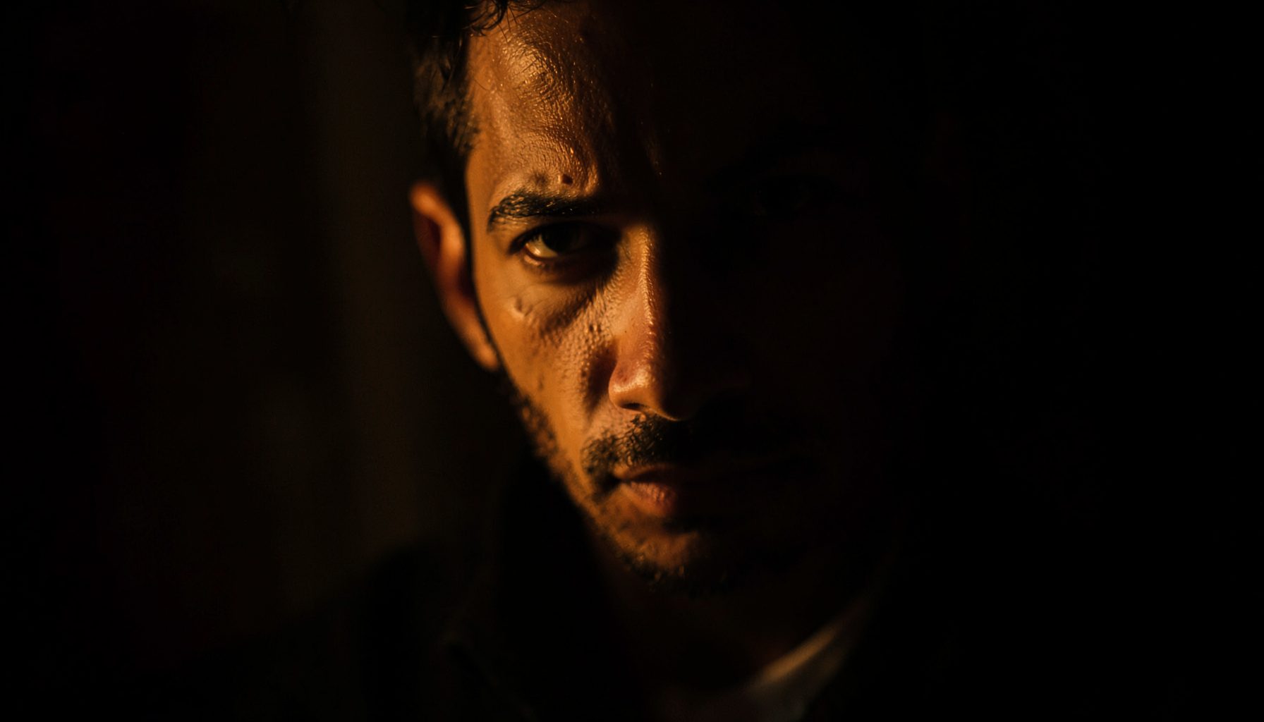 A moody close-up composition with deep shadows and warm highlights, cinematic and dramatic in feel.